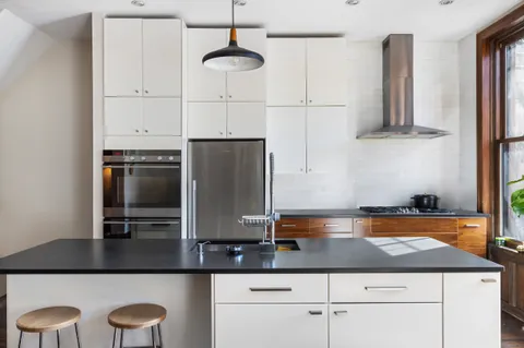 a kitchen with stainless steel appliances granite countertop a sink a stove and refrigerator