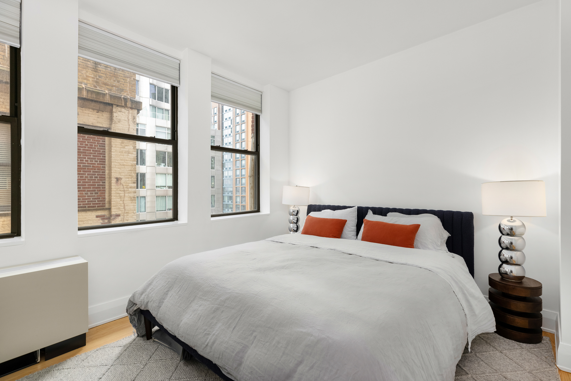 150 Nassau Street, Unit 19A Manhattan, NY 10038 - Photo 6 of 16 a bedroom with a bed and window