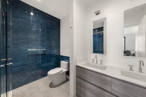 a bathroom with a sink a toilet a shower and a mirror