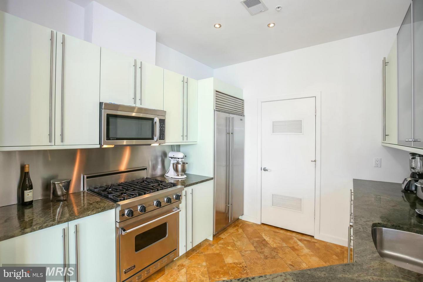 1300 13th Street Northwest, Unit 905 Washington, DC 20005 - Photo 6 of 18 a kitchen with white cabinets and appliances