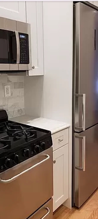 1736 2nd Avenue, Unit 4A Manhattan, NY 10128 - Photo 4 of 6 a black refrigerator freezer sitting inside of a kitchen
