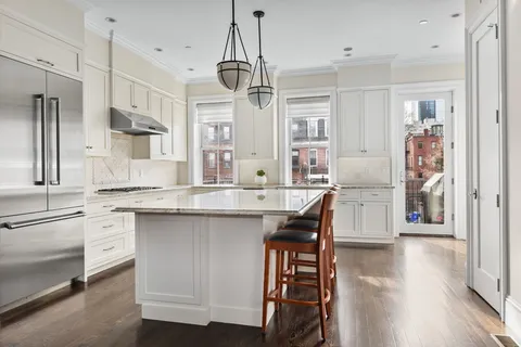 a kitchen with stainless steel appliances granite countertop a kitchen island hardwood floor and a sink