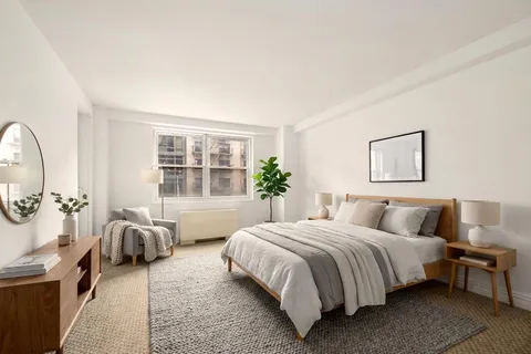 a bedroom with a bed couch and window