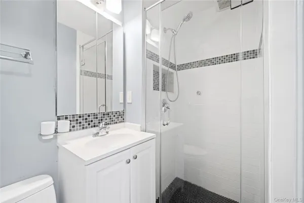 a bathroom with a sink a toilet and shower