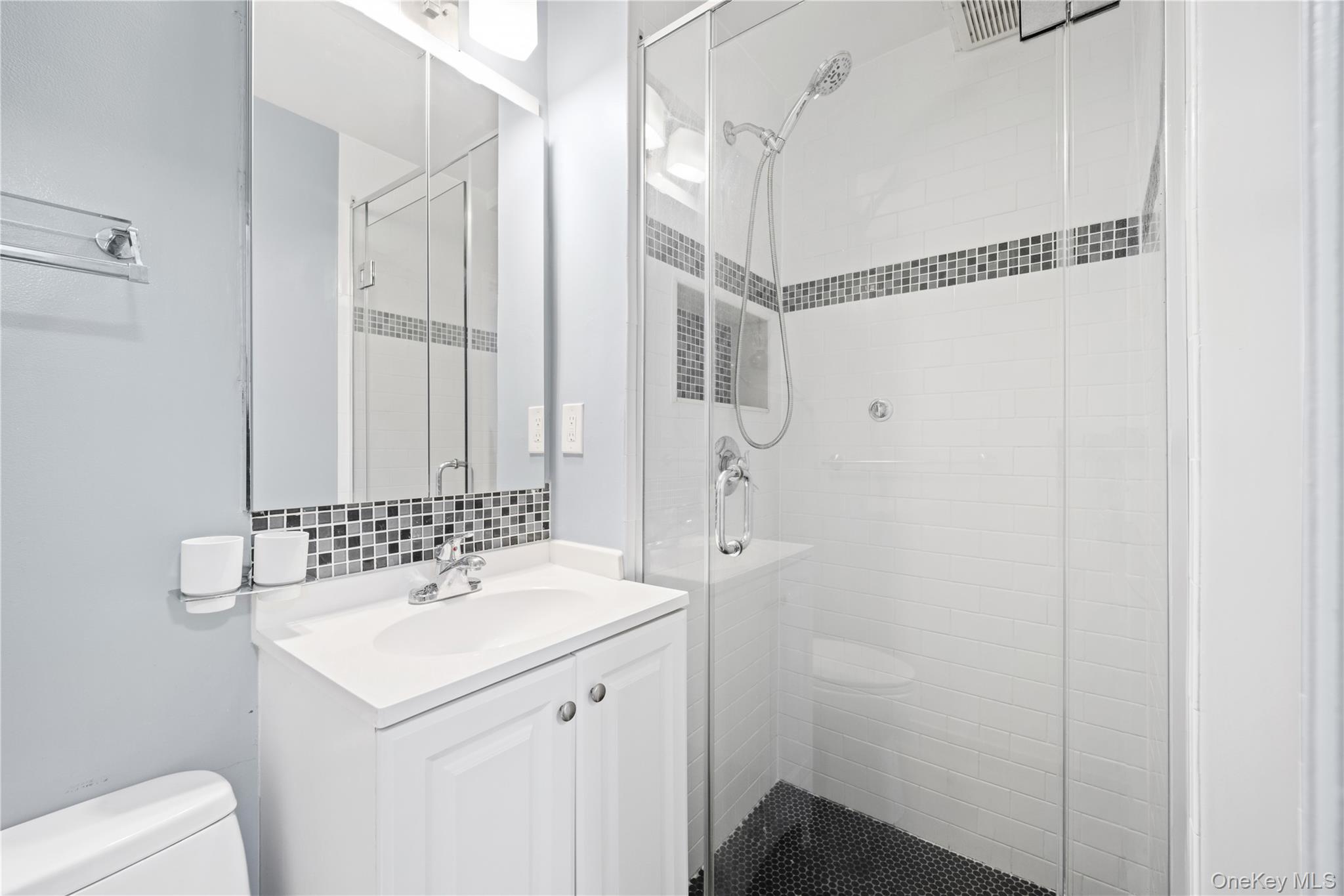 75-34 Bell Boulevard, Unit LD Queens, NY 11364 - Photo 11 of 26 a bathroom with a sink a toilet and shower