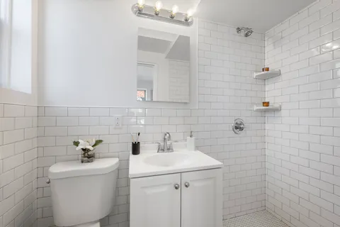 a bathroom with a sink a toilet and shower