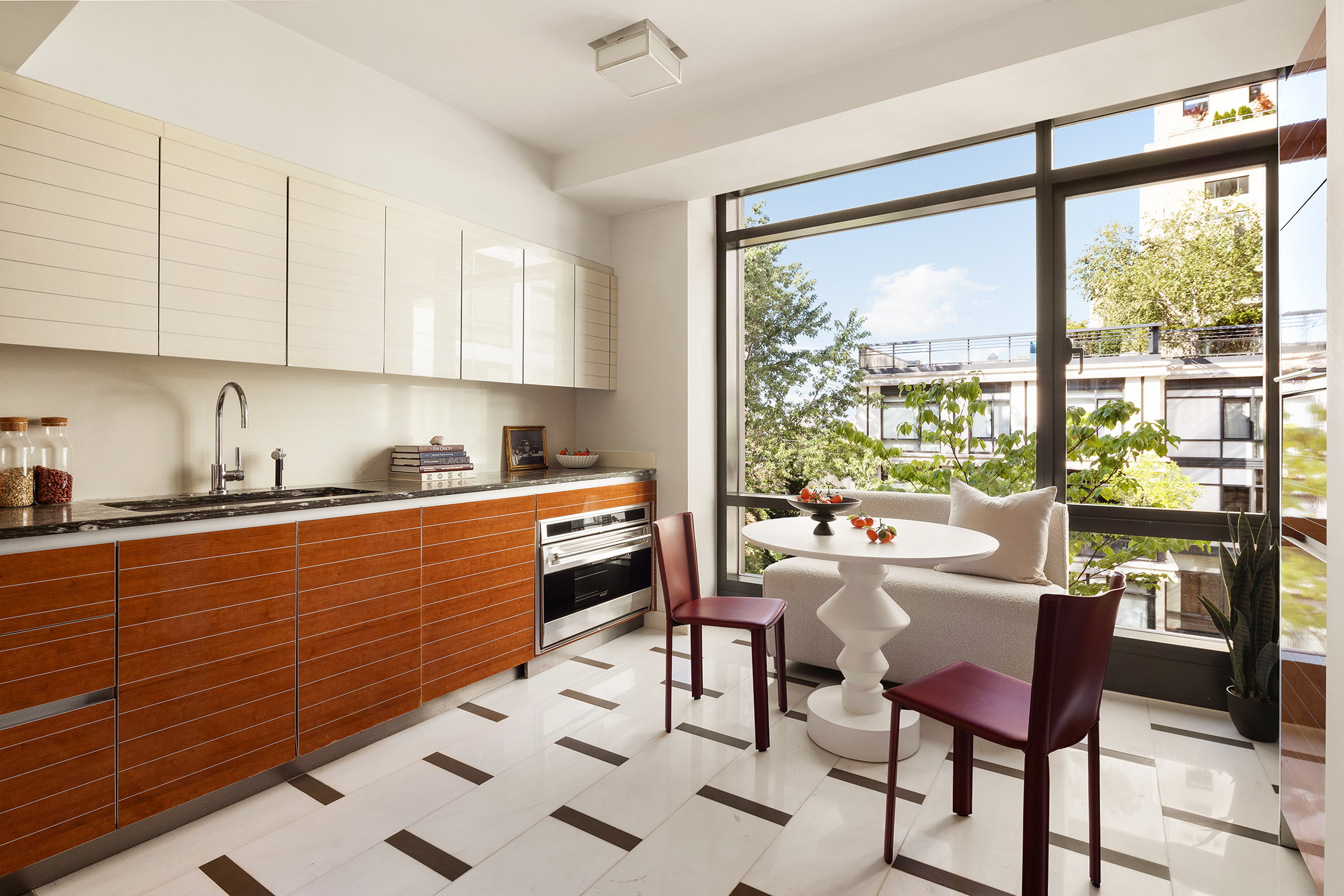 170 East End Avenue, Unit 7A Manhattan, NY 10128 - Photo 4 of 35 a kitchen with stainless steel appliances granite countertop sink microwave dining table and chairs