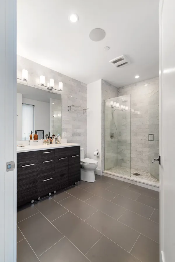 a bathroom with a double vanity sink toilet and shower