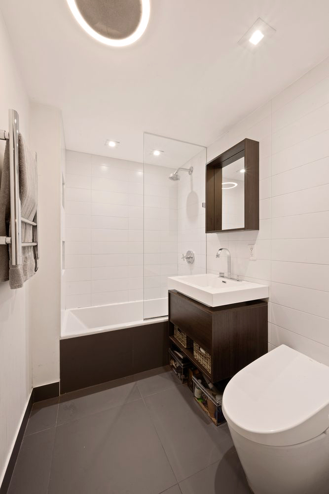 138 North 3rd Street, Unit 1 Brooklyn, NY 11249 - Photo 8 of 9 a bathroom with a sink a toilet and mirror