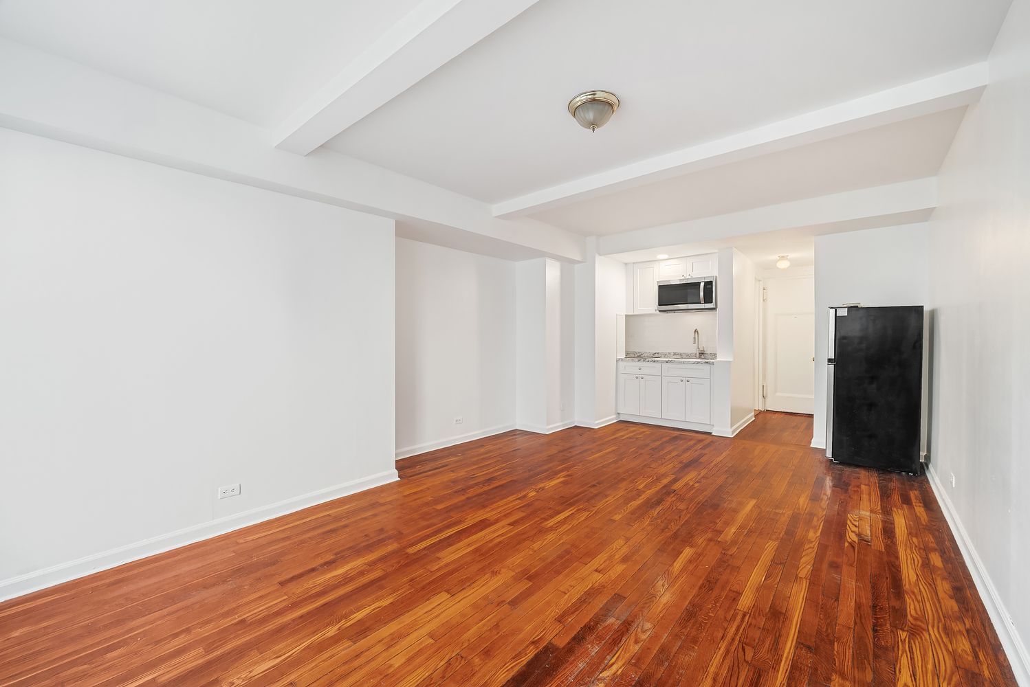 320 East 42nd Street, Unit 407 Manhattan, NY 10017 - Photo 3 of 3 a big room with wooden floor and windows