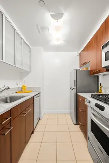 a kitchen with a sink a stove top oven and cabinets