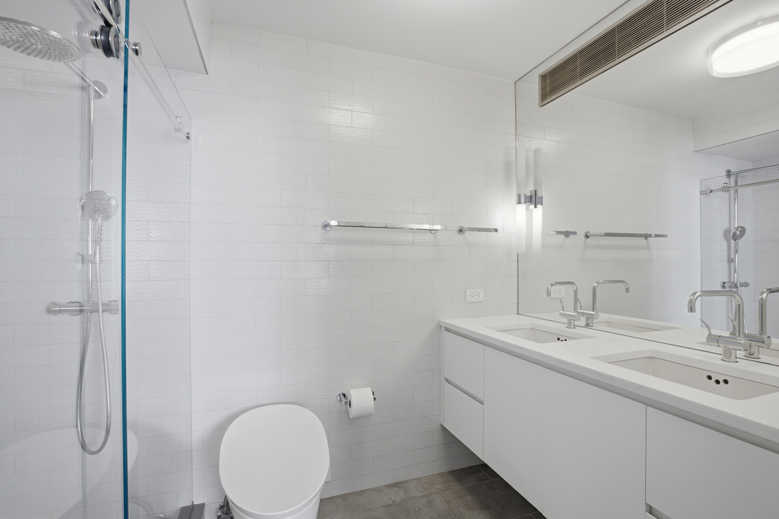 309 East 49th Street, Unit 21A Manhattan, NY 10017 - Photo 11 of 18 a bathroom with a double vanity sink and mirror
