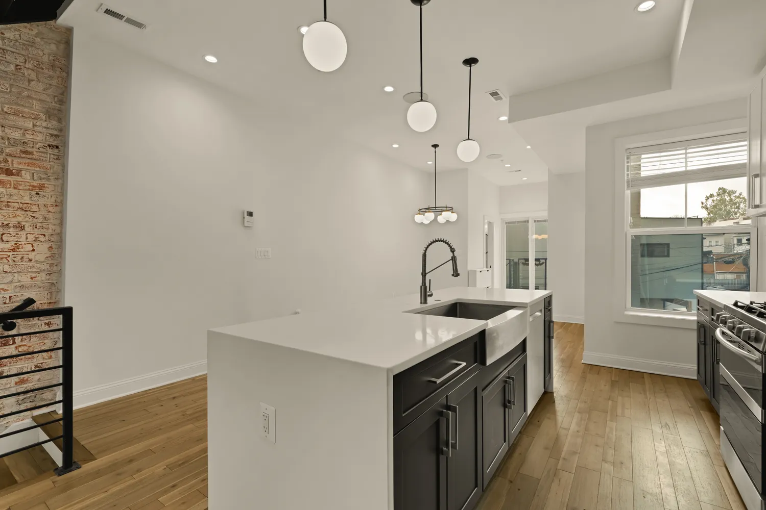 a kitchen with stainless steel appliances granite countertop a sink a stove and a wooden floors