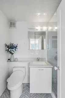 a bathroom with a toilet sink and mirror