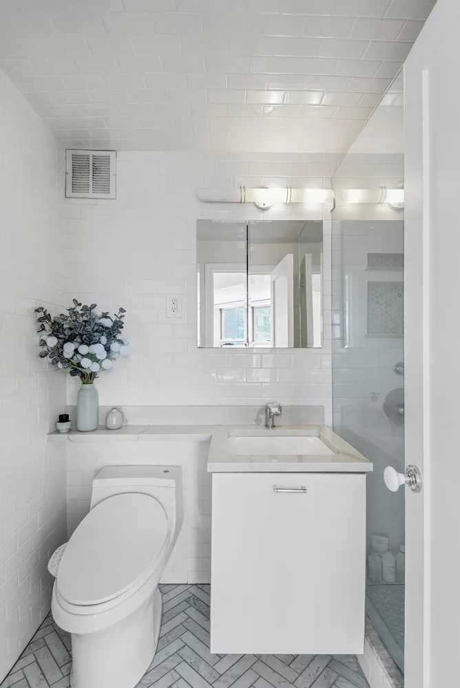 a bathroom with a toilet sink and mirror