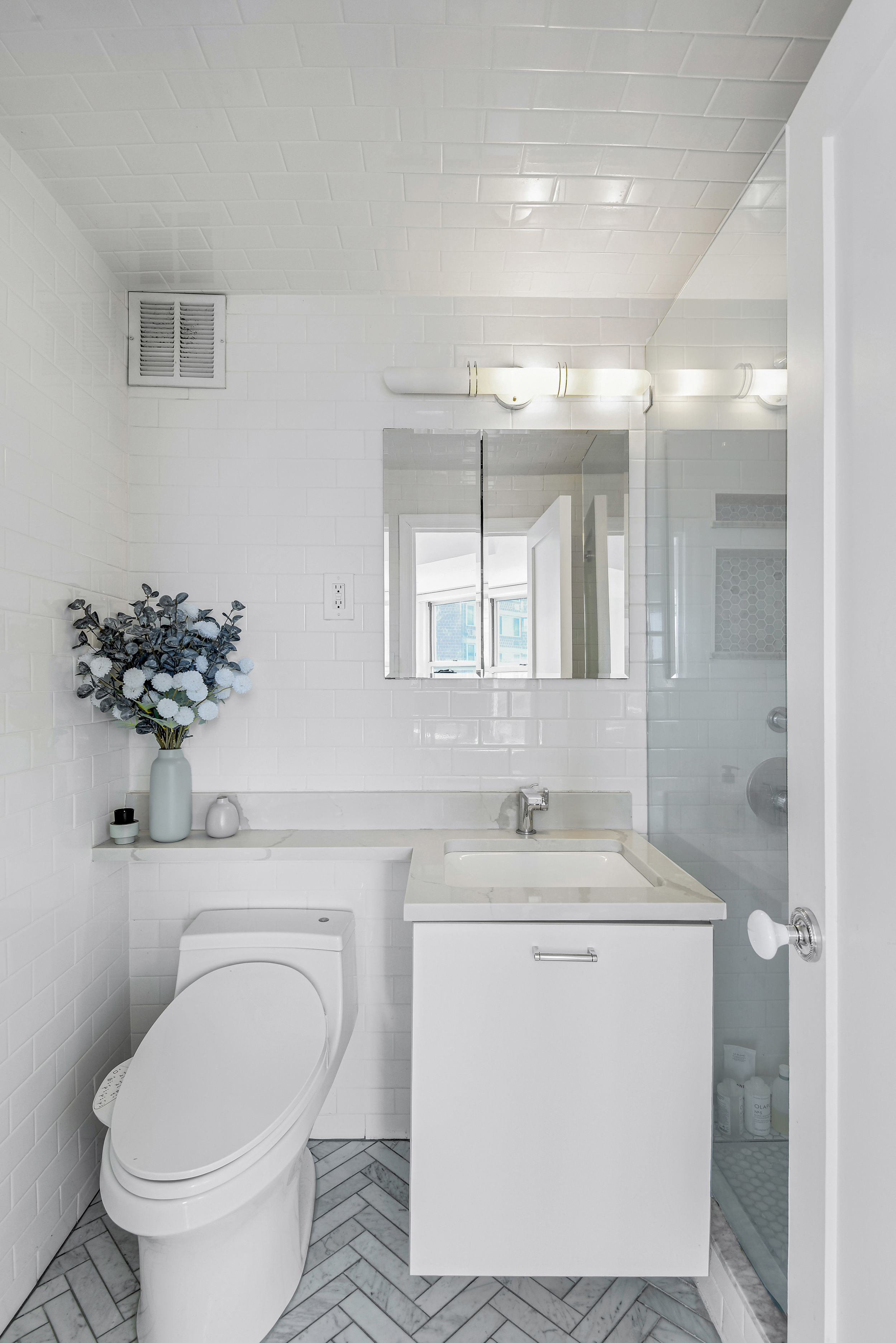 305 East 24th Street, Unit PHL Manhattan, NY 10010 - Photo 6 of 10 a bathroom with a toilet sink and mirror