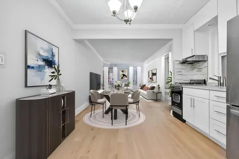 a kitchen with a table chairs refrigerator and cabinets