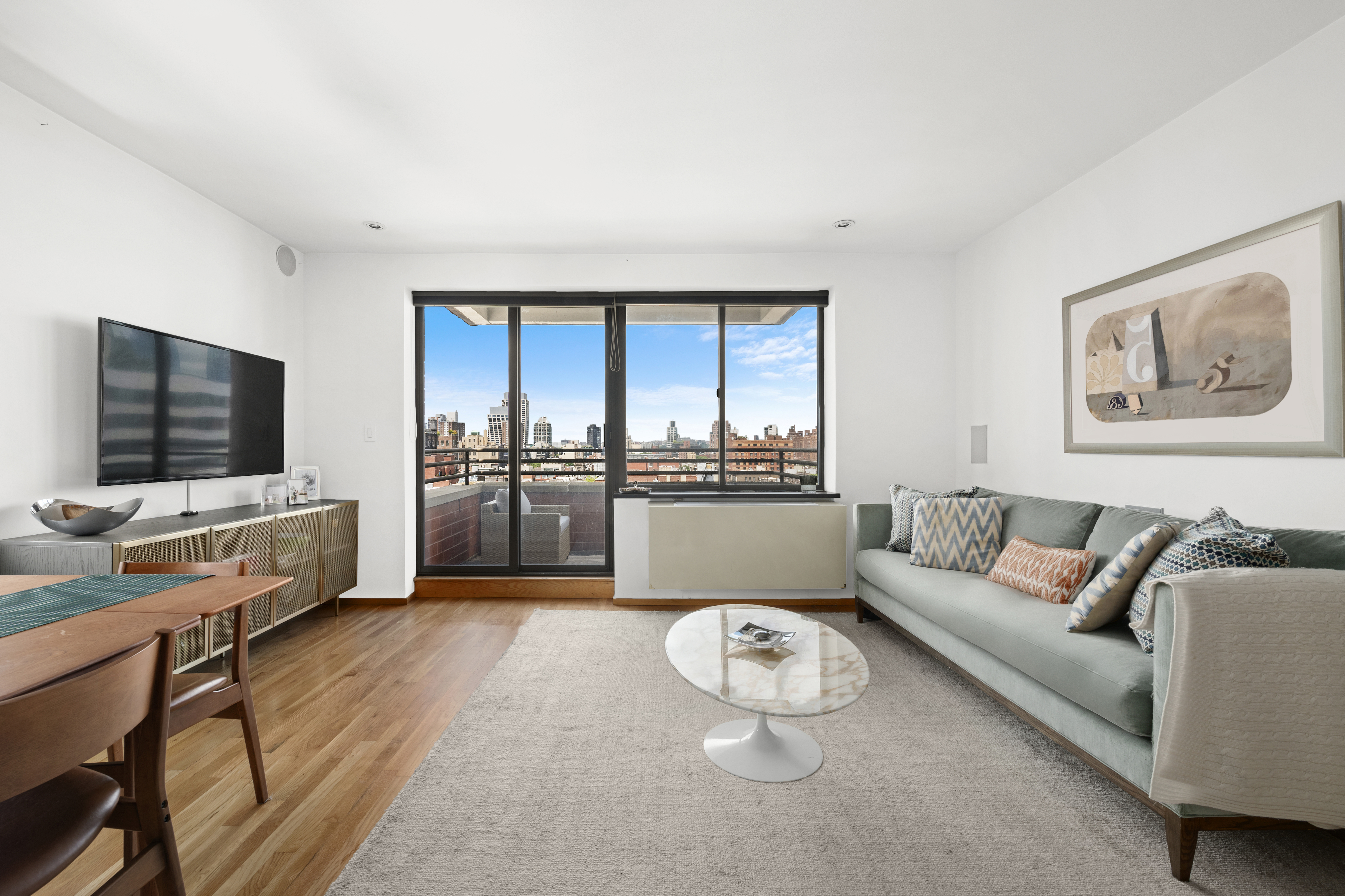 181 7th Avenue, Unit 11A Manhattan, NY 10011 - Photo 2 of 13 a living room with furniture and a flat screen tv