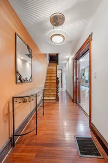 a view of a hallway with wooden floor and entryway