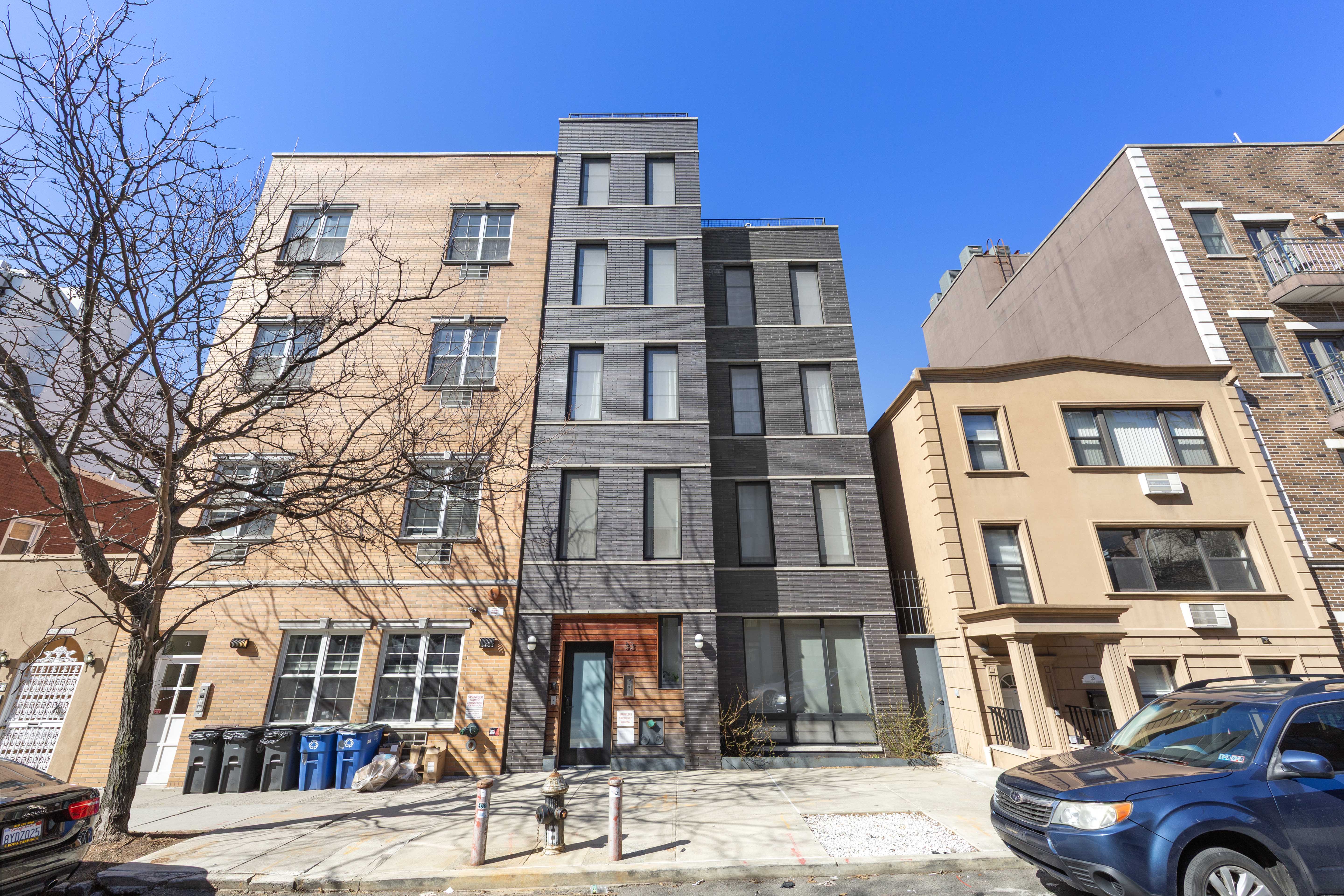 33 Conselyea Street, Unit PH Brooklyn, NY 11211 - Photo 15 of 16 a front view of a building with lot of cars and trees