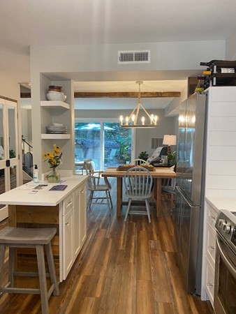 10 Beal's Cove Road, Unit E Hingham, MA 02043 - Photo 8 of 12 a dining hall with stainless steel appliances kitchen island a stove a table and chairs
