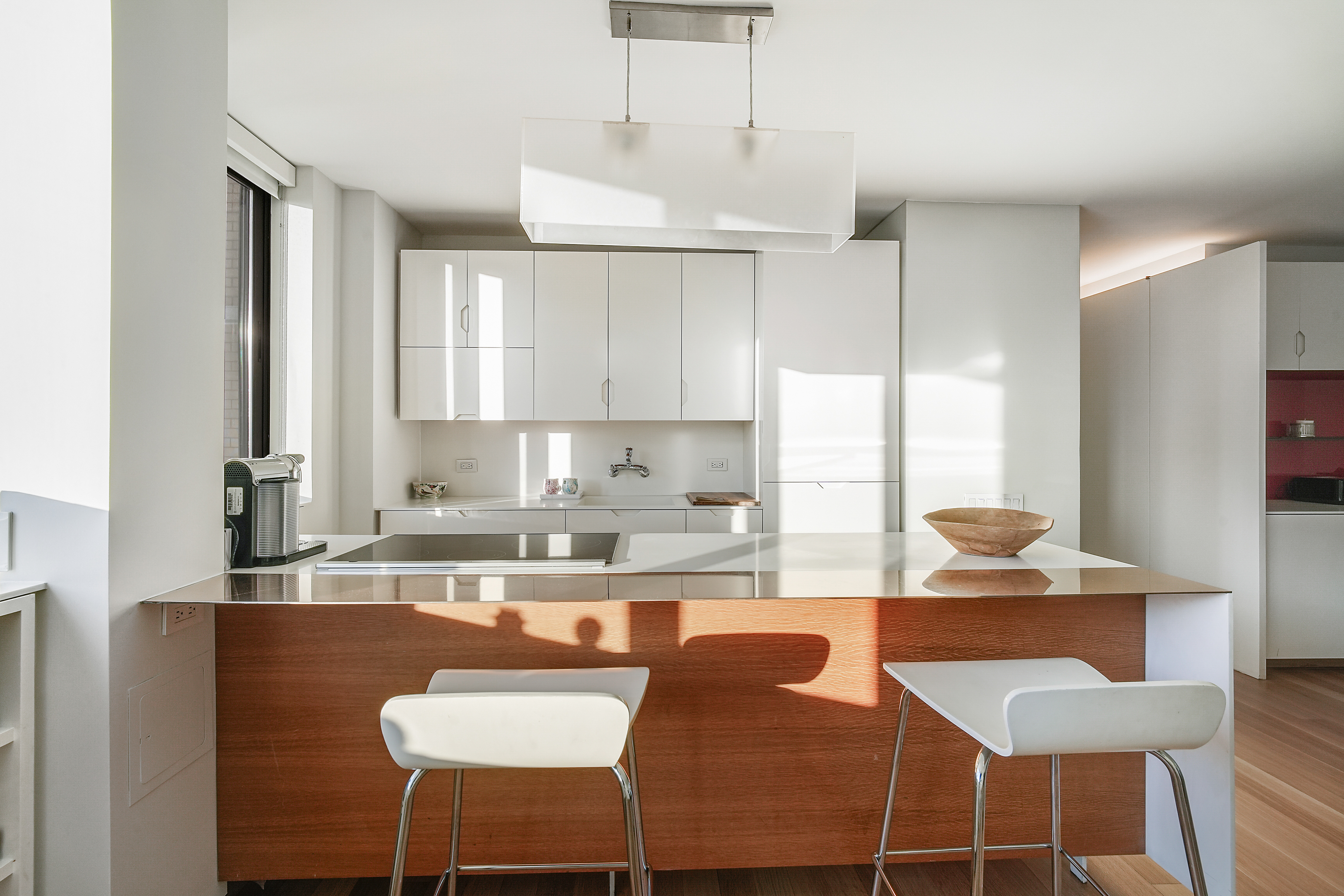 280 Park Avenue South, Unit 20C Manhattan, NY 10010 - Photo 8 of 17 a kitchen with a dining table chairs and white cabinets