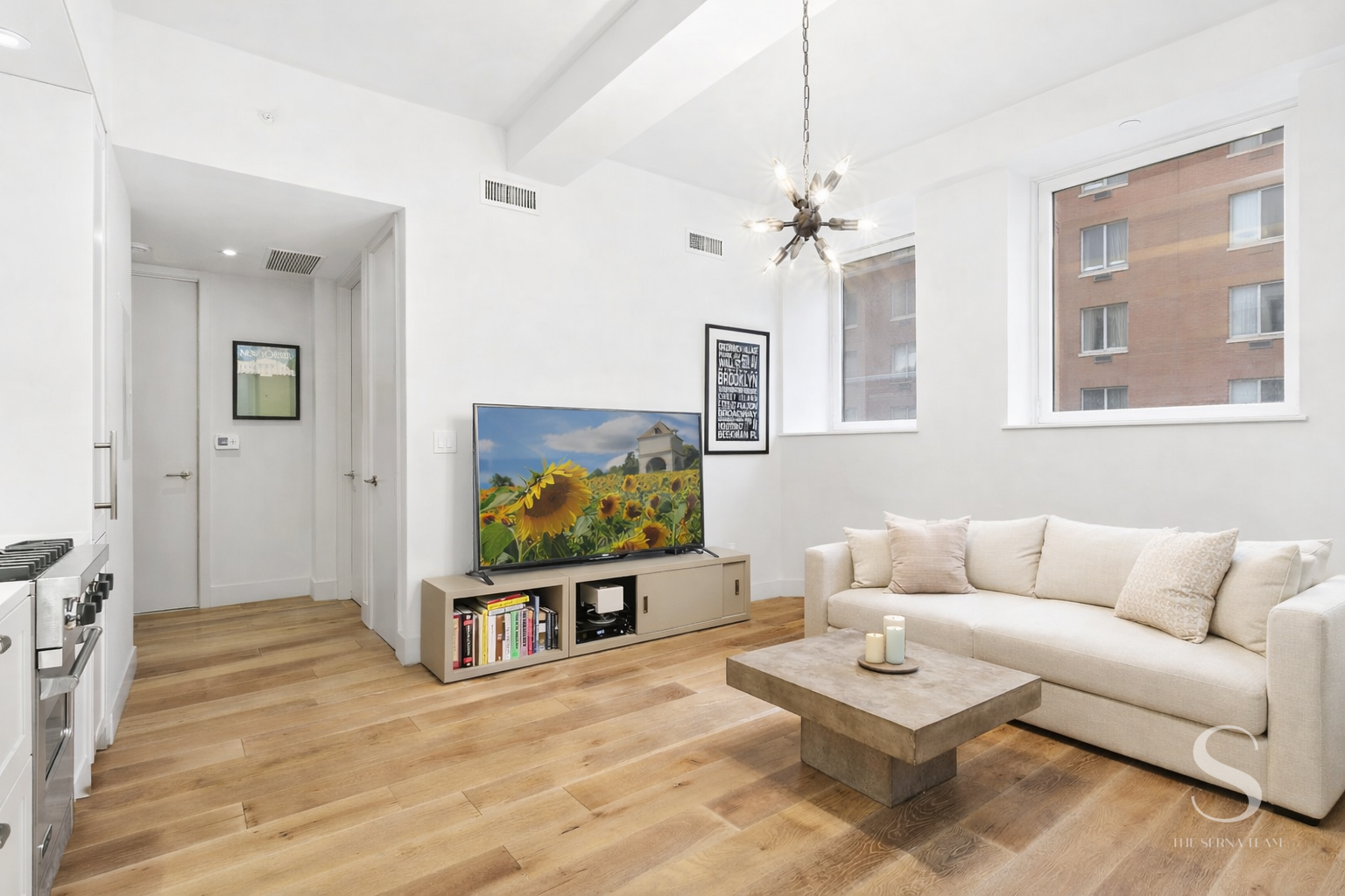93 Worth Street, Unit 302 Manhattan, NY 10013 - Photo 2 of 10 a living room with furniture and a flat screen tv