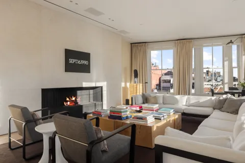 a living room with furniture a large window and a fireplace