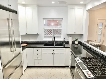 a kitchen with granite countertop a stove sink and cabinets