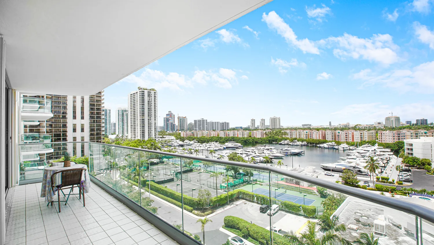 a view of a city from a balcony with outdoor seating