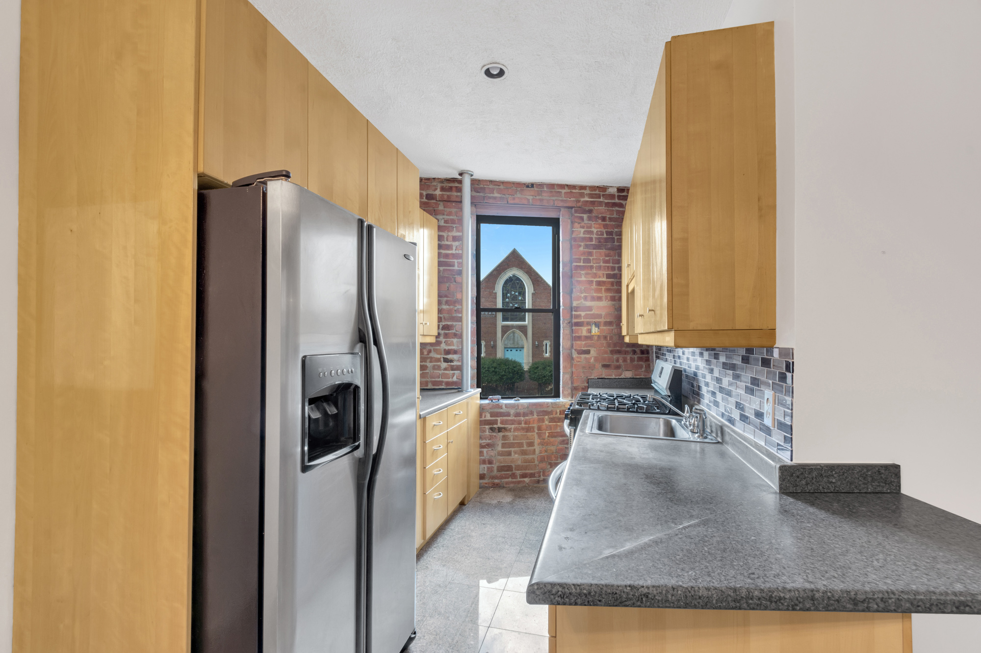 7609 4th Avenue, Unit B1 Brooklyn, NY 11209 - Photo 8 of 17 a kitchen with stainless steel appliances granite countertop a refrigerator a stove and a sink with wooden floor