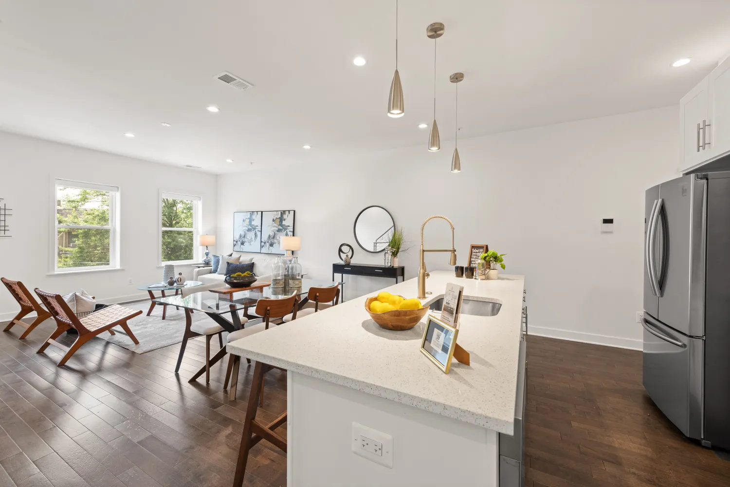 a view of a kitchen and dining room with a table wooden floor windows and a kitchen