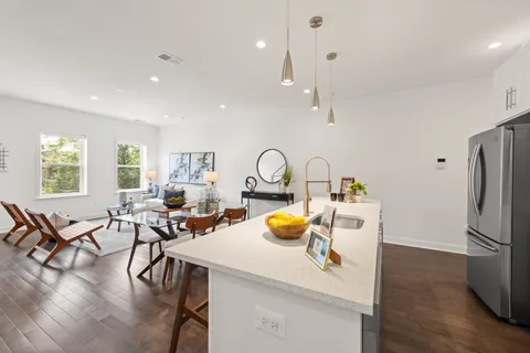a view of a kitchen and dining room with a table wooden floor windows and a kitchen