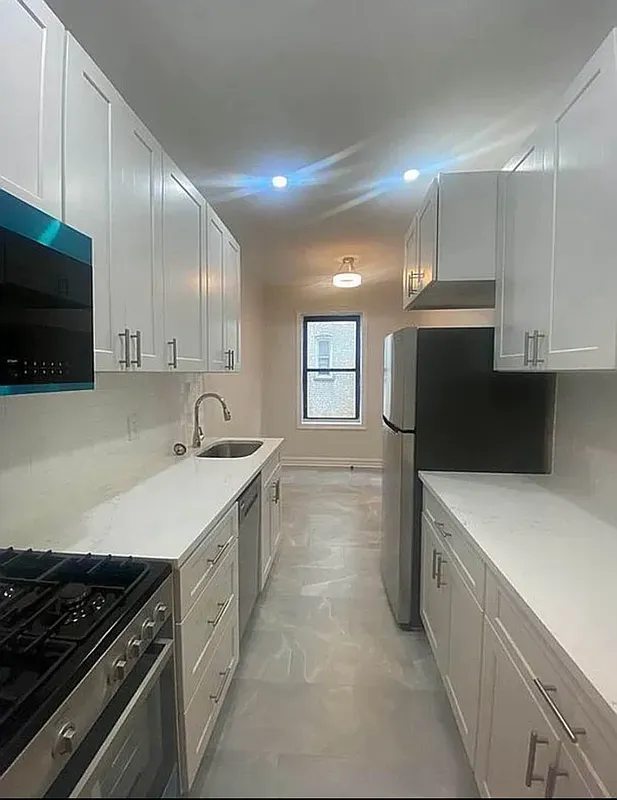 a kitchen with a sink stove top oven and cabinets