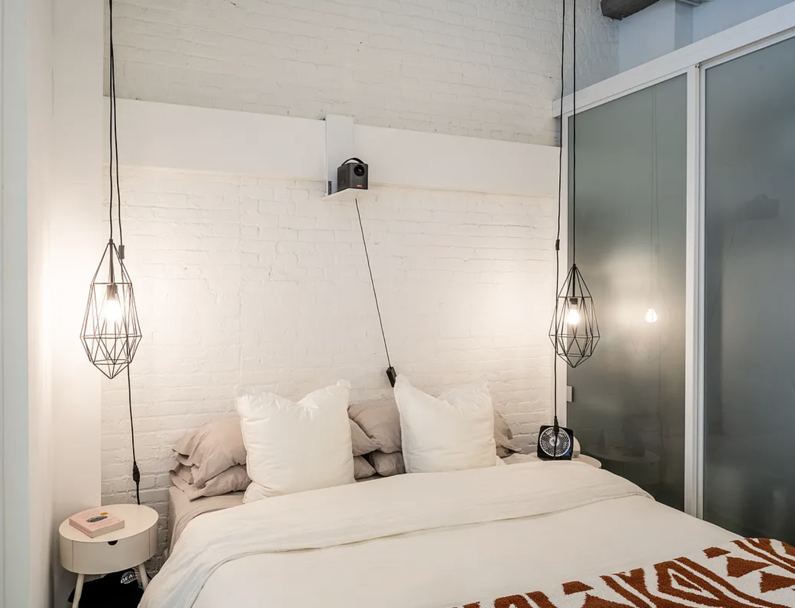 44 Berry Street, Unit 5E Brooklyn, NY 11249 - Photo 5 of 9 a bedroom with a bed and a chandelier