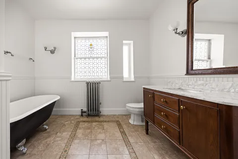 a bathroom with a sink a toilet and mirror