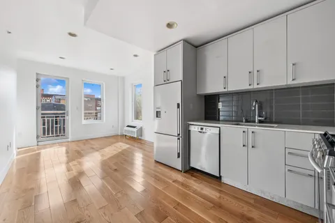 a kitchen with white cabinets and white appliances
