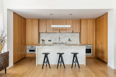 a kitchen with stainless steel appliances granite countertop a table chairs sink and cabinets