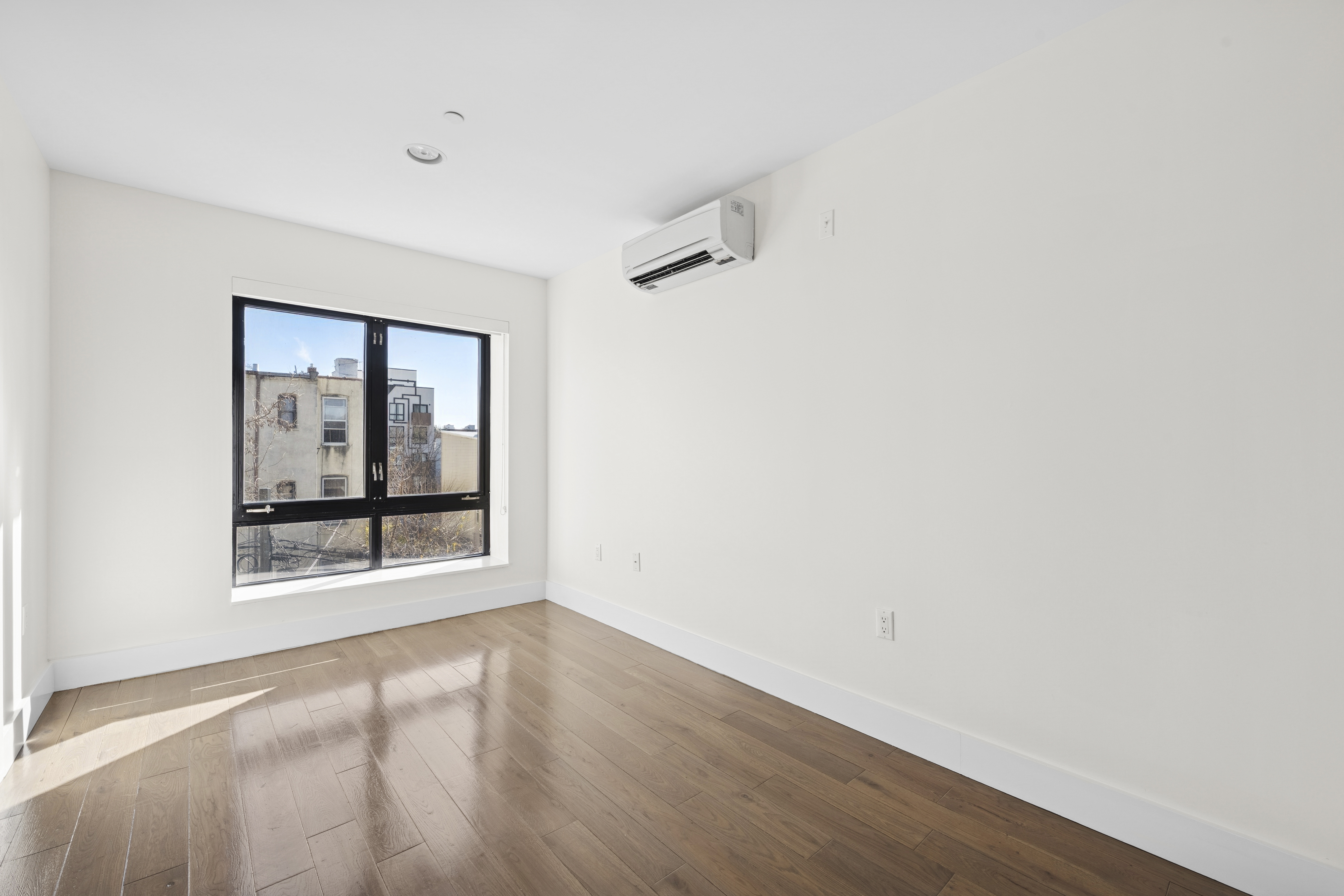 1164 Greene Avenue, Unit 3A Brooklyn, NY 11221 - Photo 7 of 11 a view of an empty room with wooden floor and a window