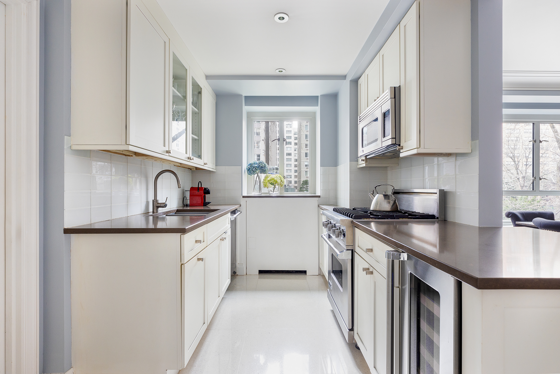 200 East 66th Street, Unit E207 Manhattan, NY 10065 - Photo 4 of 12 a kitchen with stainless steel appliances granite countertop a sink stove and refrigerator