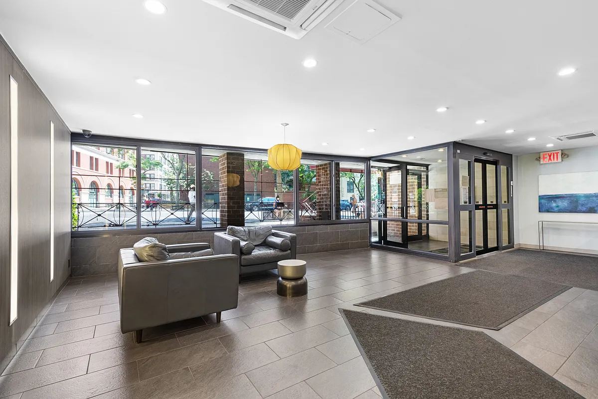 165 Christopher Street, Unit 5AA Manhattan, NY 10014 - Photo 7 of 9 a living room with furniture and a large window