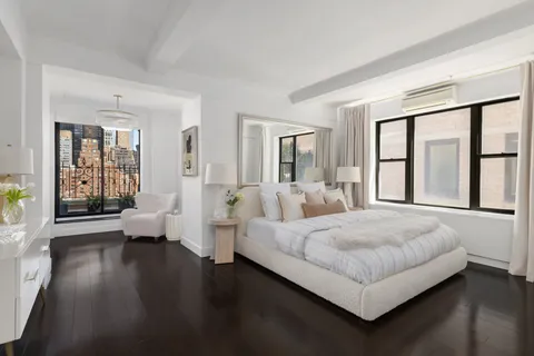 a bedroom with a large bed and wooden floor