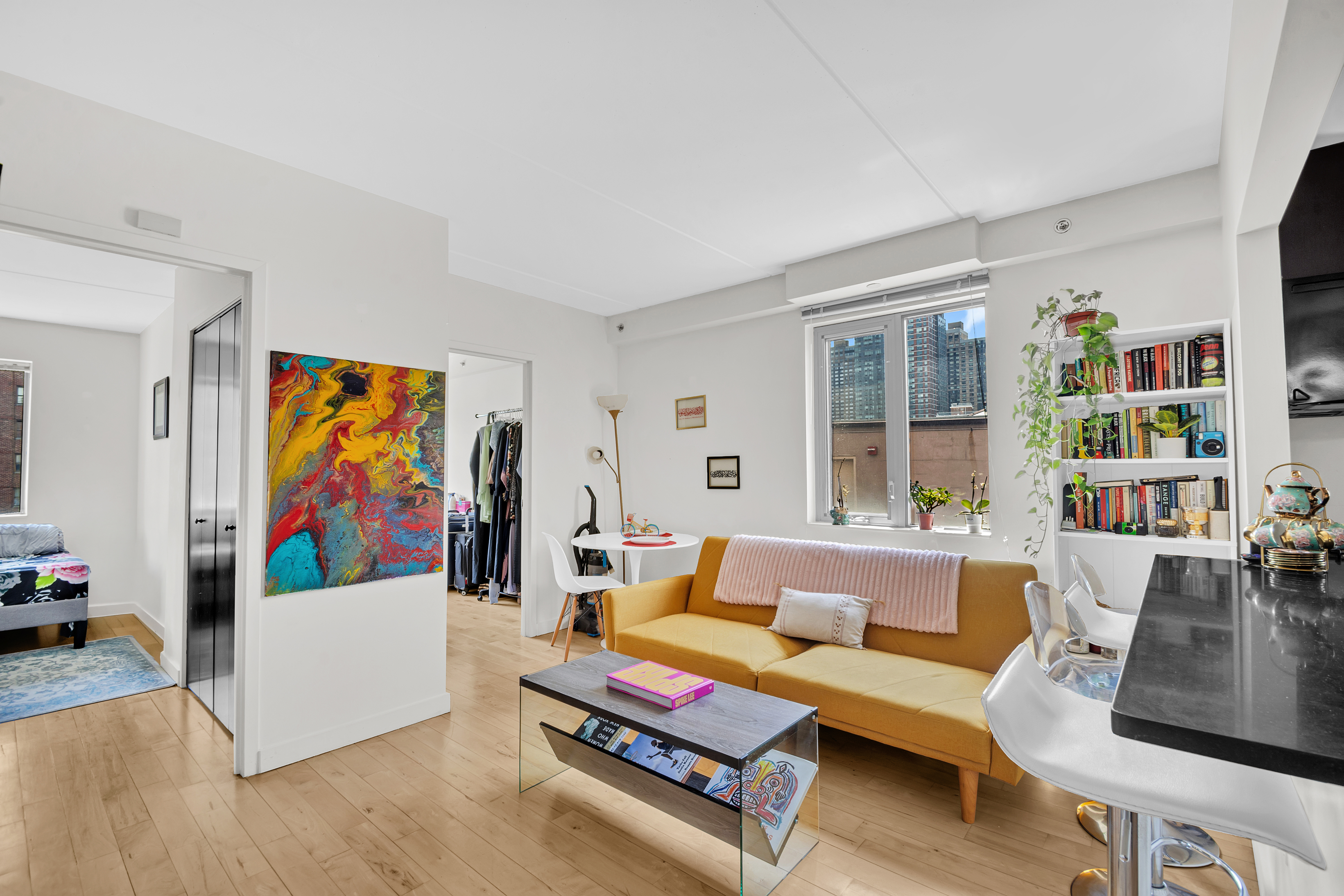 1810 3rd Avenue, Unit A7D Manhattan, NY 10029 - Photo 2 of 13 a living room with furniture and a bookshelf with wooden floor