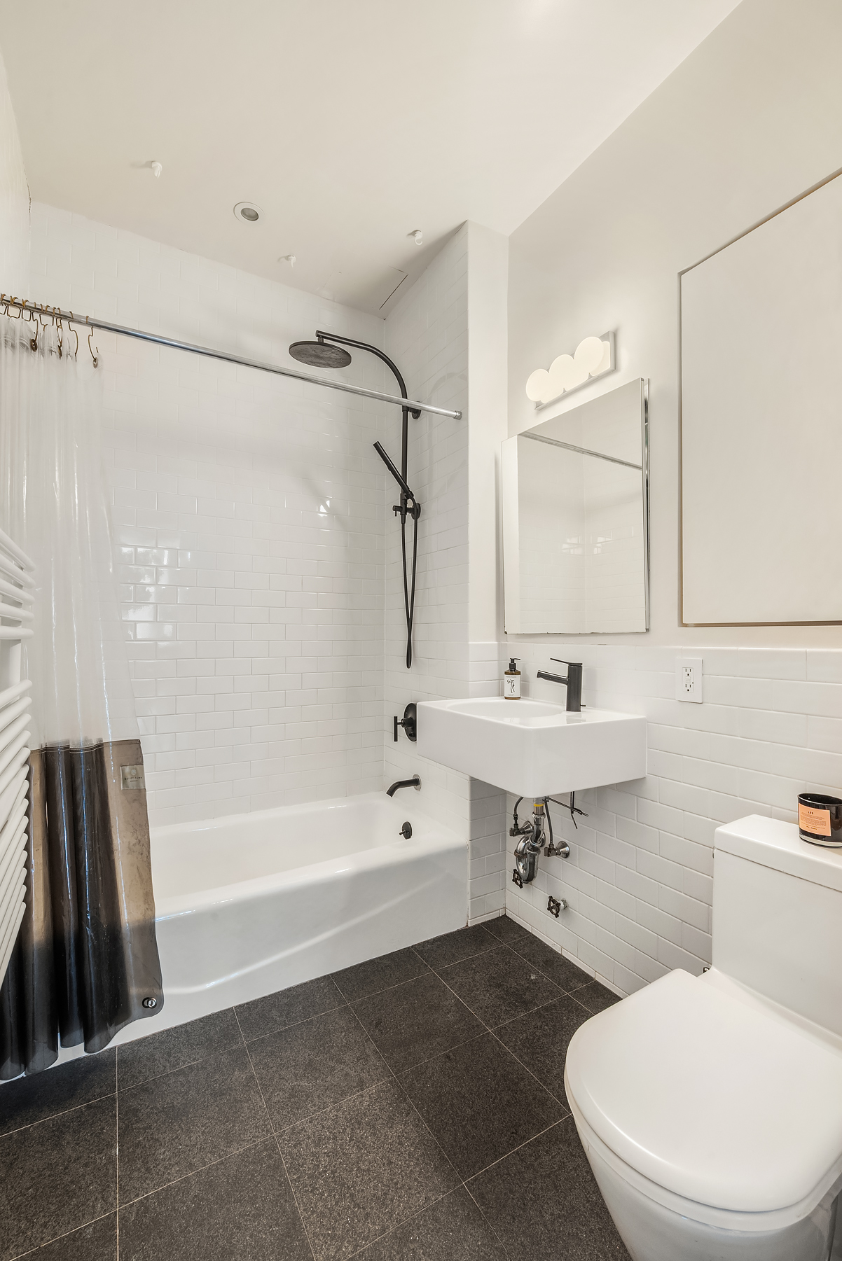 175 East Broadway, Unit 4C Manhattan, NY 10002 - Photo 8 of 14 a bathroom with a sink a toilet and shower