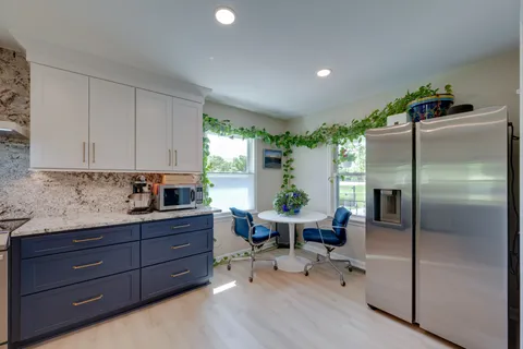 a large kitchen with stainless steel appliances granite countertop a lot of counter space and a sink
