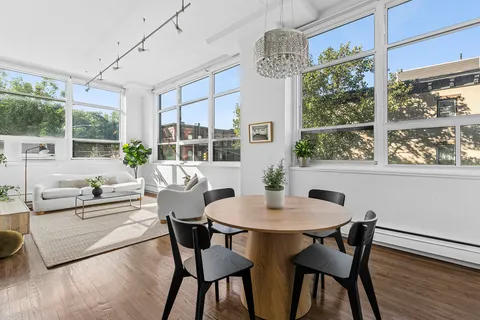 a dining room with furniture a chandelier and wooden floor