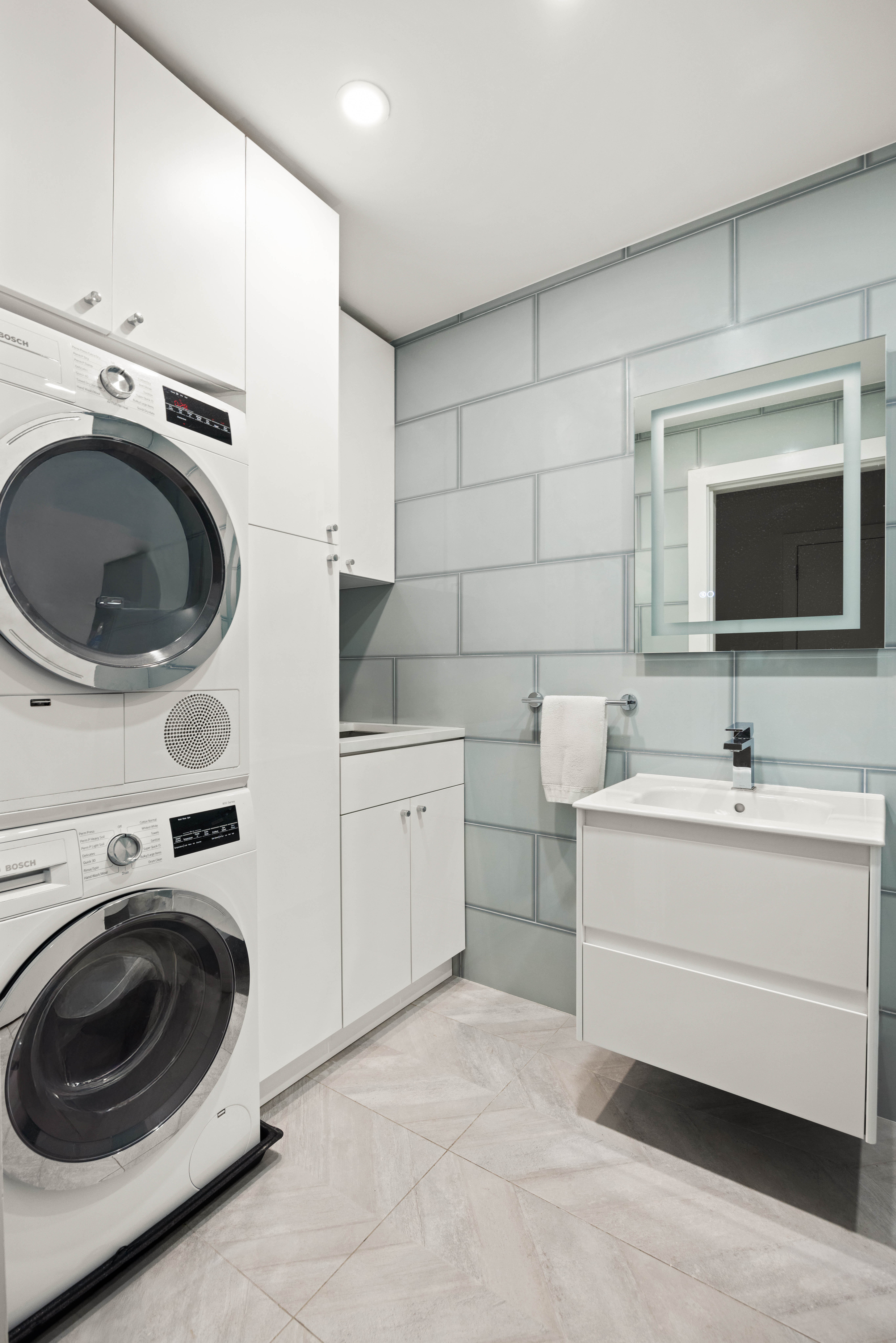 136 East 56th Street, Unit 4EF Manhattan, NY 10022 - Photo 9 of 10 a utility room with sink dryer and washer
