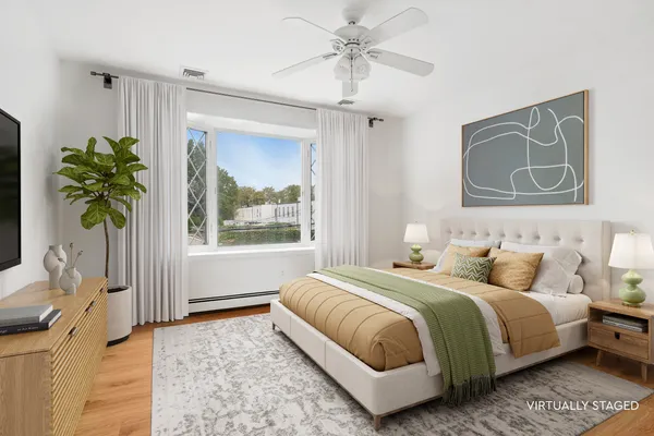 a bedroom with a bed lamp and a potted plant