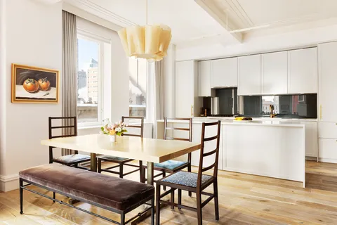 a living room with couches a flat screen tv and kitchen view