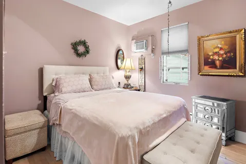 a bedroom with a bed and a painting on the wall